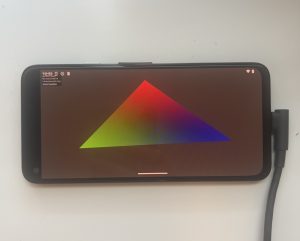 A KDGpu example running natively on an Android device. It comprises of a rotating multicolored triangle on a gray background. 